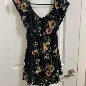 Black floral off shoulder romper with tassel detail. Like new condition. Size M.